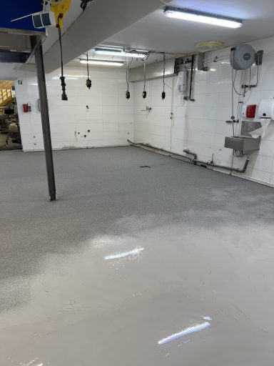 Beschichtung und Einstreuung Arbeitsstand beim Auftragen der Beschichtung mit eingestreutem Material.