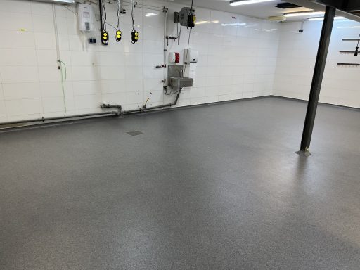 Fertige Großküche Fertiger grauer Beschichtungsboden in einer Großküche mit Bodenablauf und Sockelanschlüssen.